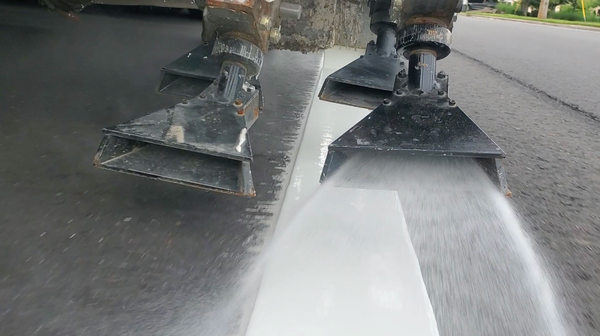 Road construction bead gun showing reflective beads being applied to road striping